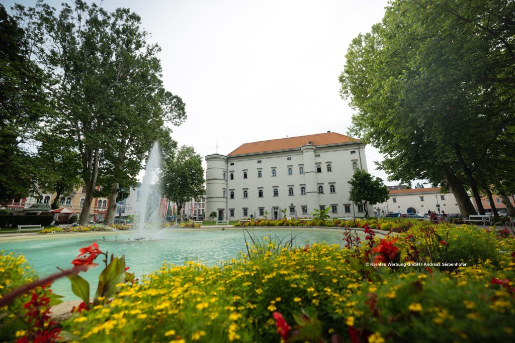 Schloss Porcia in Spittal an der Drau mit Brunnen und Gartenanlage vor dem historischen Gebäude